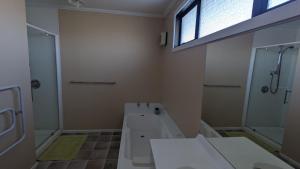 a bathroom with a toilet and a shower and a sink at Polka Apartment in Ranfurly +4 photos