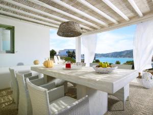 una mesa y sillas blancas con vistas al océano en Ninos Houses, en Provatas