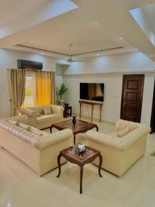 a large living room with couches and a table at Dahlia By T2R, 3BHK Bahria Town Phase 7, Close To DHA-1 Islamabad in Rawalpindi
