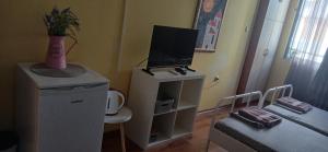 a room with a television on top of a dresser at Стая за двама в град Бургас in Burgas City