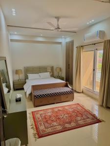 a bedroom with a large bed and a window at Dahlia By T2R, 3BHK Bahria Town Phase 7, Close To DHA-1 Islamabad in Rawalpindi