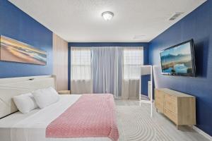 une chambre avec un grand lit et un mur bleu dans l'établissement Lakefront Luxury Retreat 5BR, à Jacksonville 61 autres photos