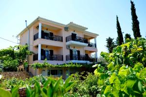 a building with balconies and trees at Despoina Rooms in Tsoukalades