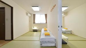 Cette chambre dispose d'une rangée d'oreillers sur le mur. dans l'établissement Business Hotel BL Kuwana, à Kuwana 201 autres photos