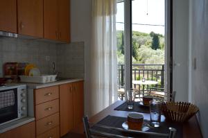 a kitchen with a table and a view of a balcony at Despoina Rooms in Tsoukalades