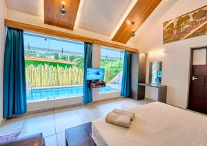a bedroom with a bed and a large window at Maryland Nature Stay Wayanad by VOYE HOMES in Wayanad
