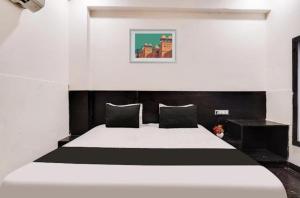 a bedroom with a large bed with black and white sheets at Hotel OPM in Agra