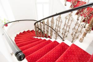 Una escalera con alfombras rojas y blancas. en Hotel Odeon, en Viena