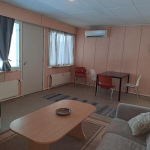 a living room with a couch and a table and chairs at Karhunkierros Apartment in Hautajärvi