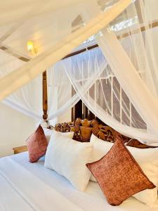 a bedroom with a bed with white sheets and pillows at The Ridge Colonial Villa - Ahangama in Ahangama