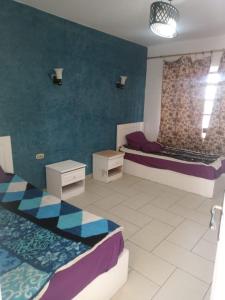 una stanza con due letti e un muro di House of Happiness a Sharm El Sheikh Altre 2 foto