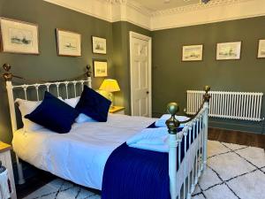 Un dormitorio con una cama blanca con almohadas azules. en The Garden Flat, en Dorchester