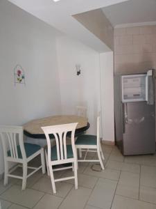una cucina con tavolo, sedie e frigorifero di House of Happiness a Sharm El Sheikh