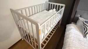 a white crib in a room with two beds at YURURIBASE 凛 in Nagahama contactless checkin in Nagahama