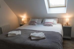 a bedroom with a bed with two towels on it at ENTRE LOIRE ET CHER Gîte "Le Nid Douillet" in Tour-en-Sologne