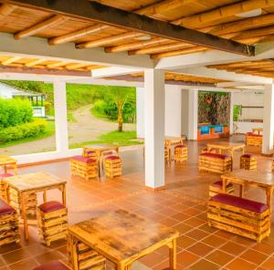 a patio with wooden tables and chairs on a patio at La Esmeralda Entre las Montañas in Ibagué