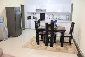 a kitchen with a table and chairs and a refrigerator at modern executive three bedroom apartment which features a swimming pool, state of the art fully equipped gym and all modern unmatched luxurious facilities which offfers luxury lifestyle in Nairobi