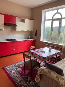 a kitchen with red cabinets and a table in a room at Holiday home in Qusar