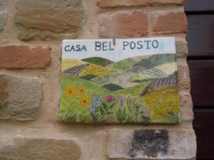 a sign on the side of a brick wall at casa Bel Posto in San Ginesio