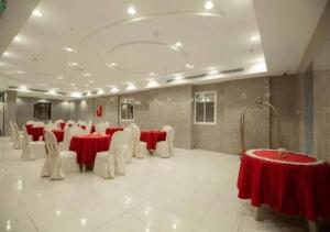 a banquet hall with red and white tables and chairs at فندق عملاق المشرق AMLAQ ALmSHRQ HOTEL in Mecca