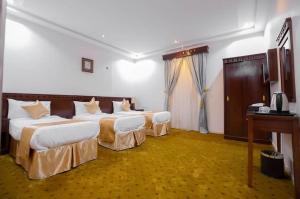 a hotel room with two beds and a desk at فندق عملاق المشرق AMLAQ ALmSHRQ HOTEL in Mecca +31 photos