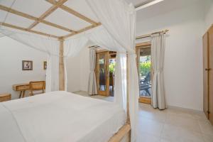 a bedroom with a white bed with a canopy at Bali Bagus Villa in Amed +38 photos