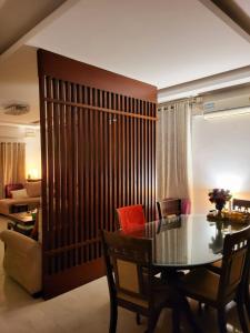 バンガロールにあるRoom lux in the premium apartments Black Orchidのテーブルとソファのあるダイニングルーム