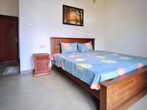a bedroom with a wooden bed and a night stand at Green villa in Galle