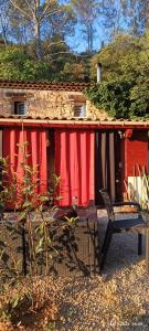 a red building with a bench in front of it at Les Jardins de Castelange in Le Thoronet