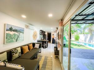 a living room with a couch and a sliding glass door at Tropical 2BR Escape & Walk to Selong Belanak Beach in Selong Belanak
