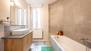a bathroom with a sink and a bath tub at Appart Cocooning 6 Personnes Hyper Centre Mulhouse in Mulhouse