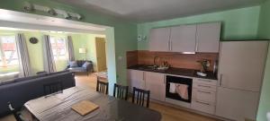 a kitchen and living room with a table and a kitchen and a dining room at La maison du tonnelier in Cleebourg +3 photos