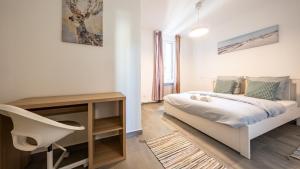 a bedroom with a bed and a desk and a chair at Appart Cocooning 6 Personnes Hyper Centre Mulhouse in Mulhouse