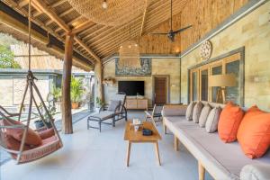 an open living room with a couch and a hammock at Bali Bagus Villa in Amed