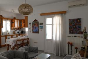 a living room with a table and a kitchen at Kamares Bay View in Sifnos