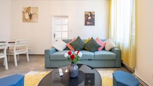 a living room with a blue couch and a table at Appart Cocooning 6 Personnes Hyper Centre Mulhouse in Mulhouse