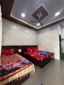 a bedroom with two beds and a ceiling at Patil residency in Matheran