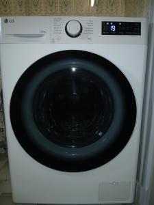 a white washing machine with a black door at Agréable appartement de 80M2 dans Maison in Lourdes