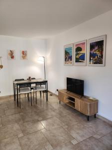 ein Wohnzimmer mit Tisch und Fernseher in der Unterkunft Cannes Paradis in Cannes