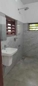 a bathroom with a white sink and a window at Traditional Kerala house, Kannur-Thalassery in Tellicherry