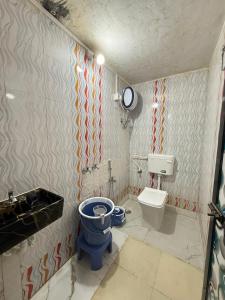 a bathroom with a blue toilet and a sink at Patil residency in Matheran