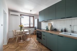 a kitchen with green cabinets and a table in it at The Nest - Komárno in Komárno