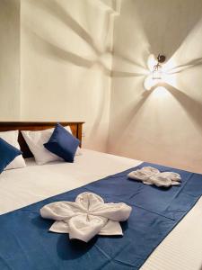 two towels on a bed in a room at Ella Hidden Ferns in Ella
