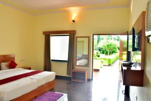 Un dormitorio con una cama, un escritorio y un espejo. en Motibagh Resort, en Sawāi Mādhopur