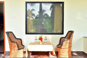 una mesa con dos sillas y una mesa con flores. en Motibagh Resort, en Sawāi Mādhopur