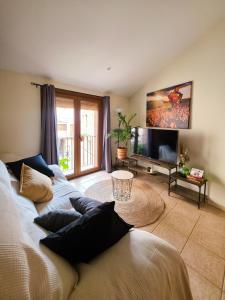a living room with a couch and a flat screen tv at La PenAlta - Allotjament enoturístic - Vilanova de Prades in Vilanova de Prades