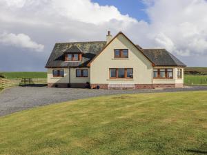 a large white house with a large grass field at Corsewall Castle Farm Lodges in Kirkcolm