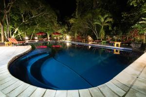 a swimming pool at night in a resort at Jungle Lodge Tikal Hostal in Tikal