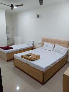 two beds sitting in a room with at Hotel Thalapathi in Chennai