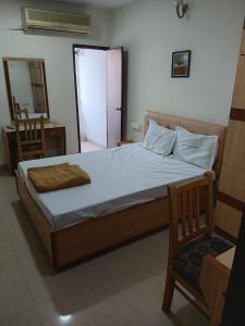 a bedroom with a bed and a desk and a chair at Hotel Thalapathi in Chennai